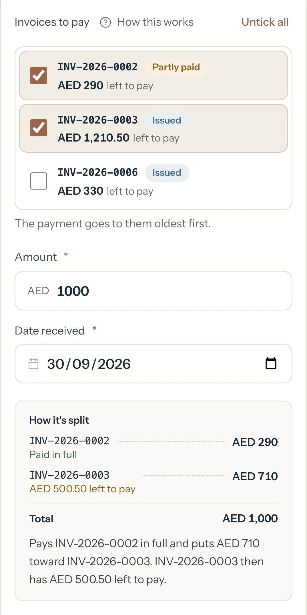 Record payment with two invoices ticked and AED 1,000 typed. How it's split shows AED 290 to the first and AED 710 to the second.