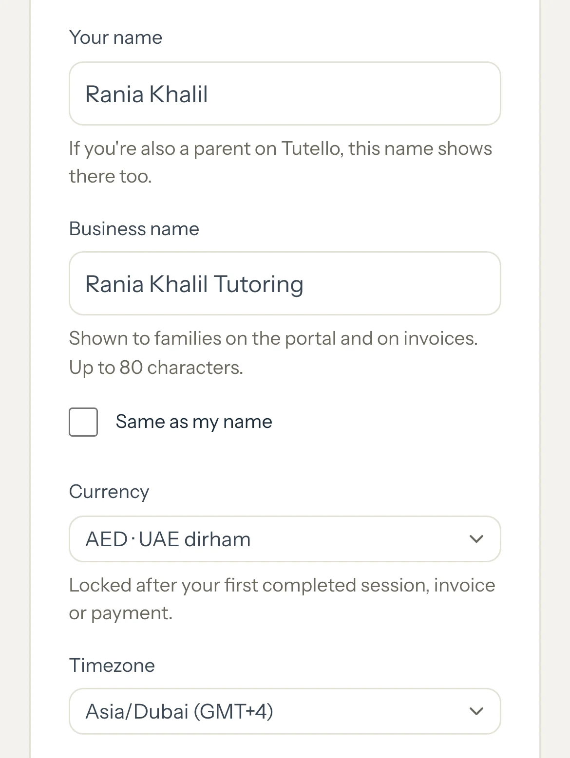 Settings Profile on a phone with Your name, Business name, Currency AED and its lock note, and Timezone.